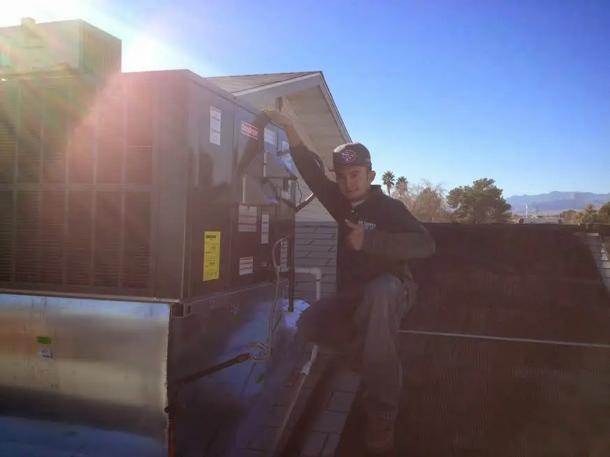 HVAC technician performing Boiler Repair on a rooftop unit in Cherokee